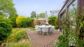 Die stilvolle Terrasse am Wintergarten bietet Raum für gesellige Abende und entspannte Stunden im Garten.