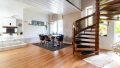 Offene Grundrissgestaltung mit Blick zur Küche und eleganter Holztreppe – ein echtes Wohnhighlight.