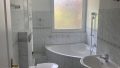 Badezimmer mit Wanne und Fenster