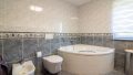 Helles Tageslichtbad mit stilvoller Eckwanne, Bidet und moderner Ausstattung – ein idealer Ort zum Entspannen.