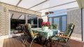 Die Terrasse, überdacht und mit direktem Zugang zum Garten – der perfekte Ort für entspannte Stunden im Freien.