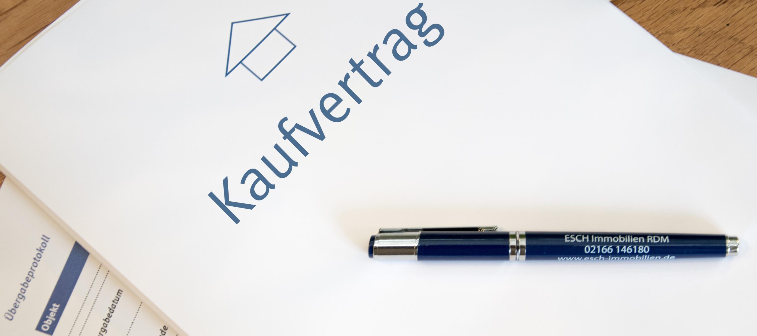 Ein Kaufvertrag mit einem Stift und ein Übergabeprotokoll.
